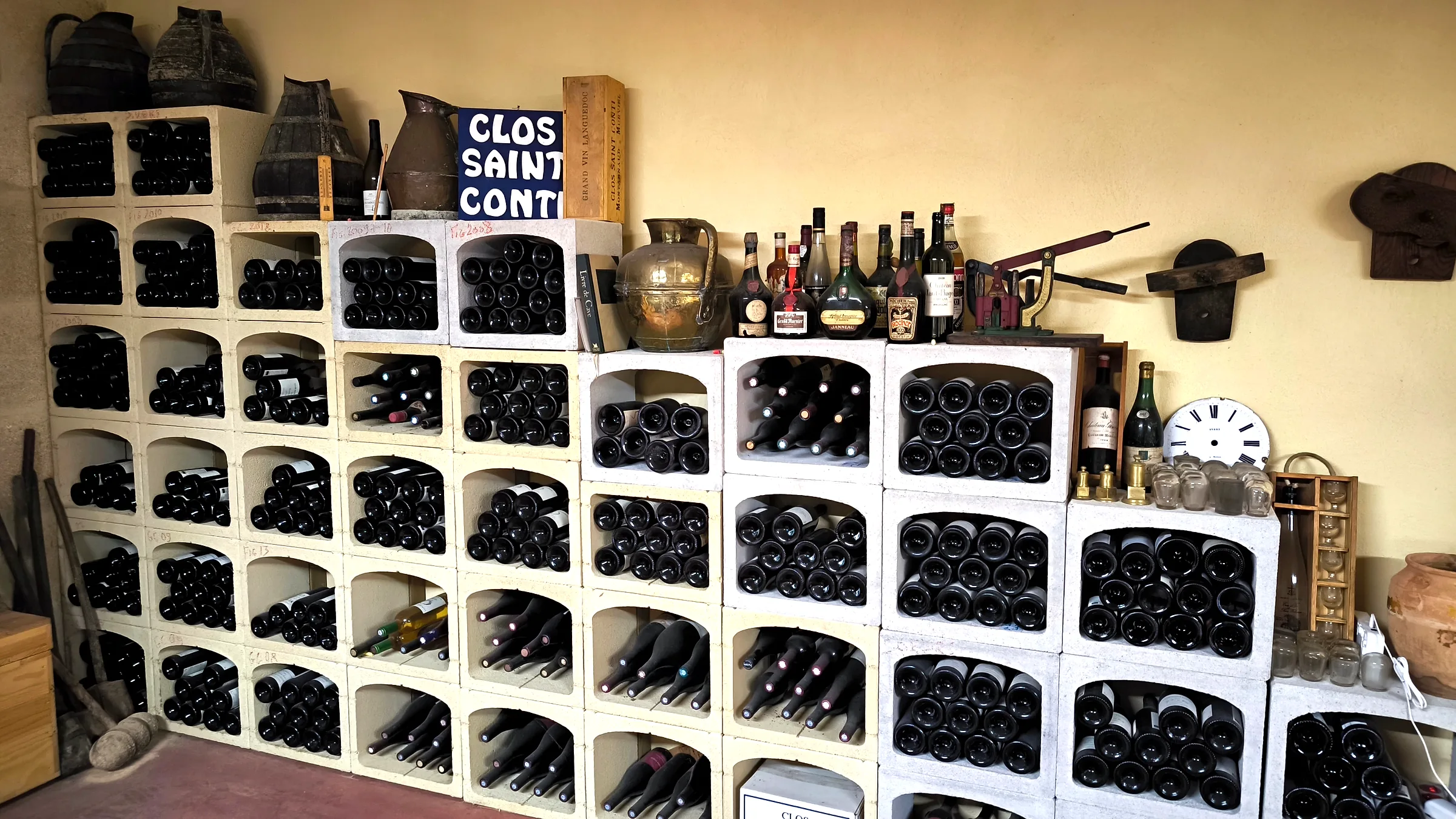 Cave du domaine : casiers de bouteilles et outils anciens